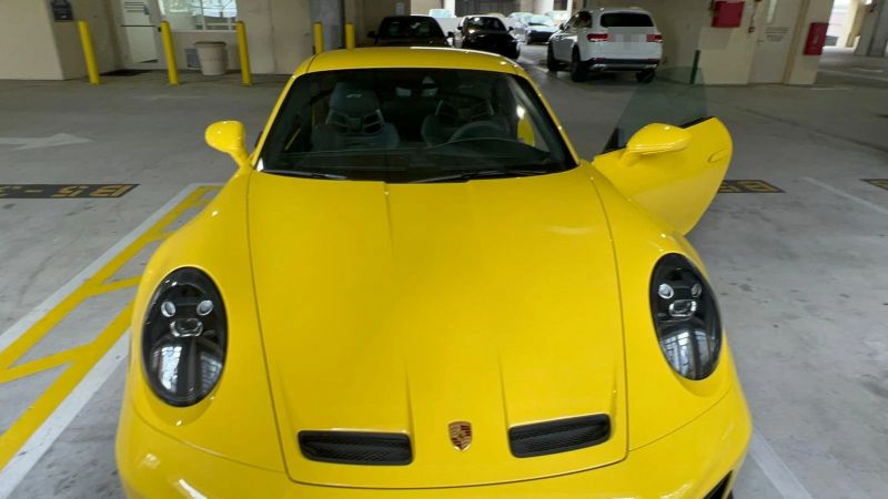 Yellow Porsche 911 GT3 front view with the driver door open